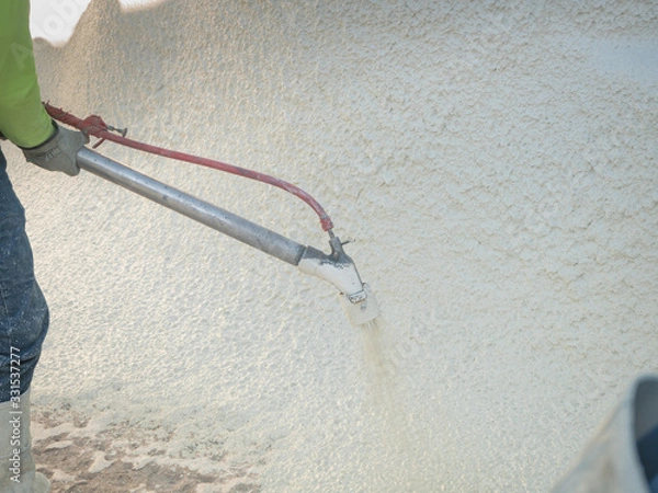 Obraz Man spraying cement during a swimming pool renovation.