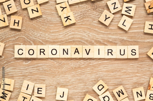 Fototapeta The word "Coronavirus" spelt out with letter tiles on the wooden background
