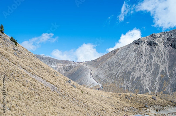 Fototapeta Volcano hills filled with excursionists.