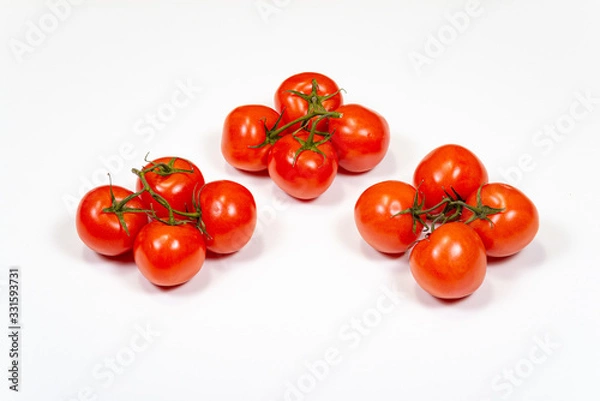 Obraz Red tomatoes on a branch on a white background, top view