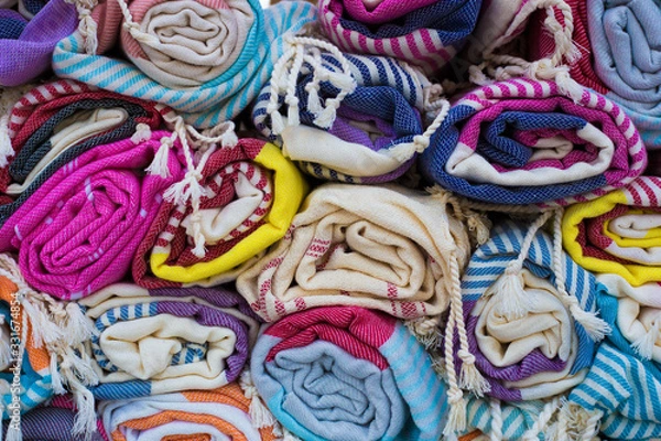 Fototapeta A bunch of twisted rugs and scarves in different colors