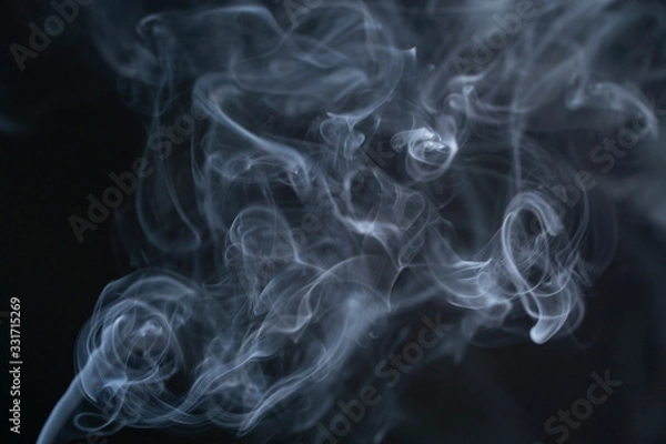 Fototapeta Blue isolated smoke on a black background. The mist is moving up, color of the indigo. The fog dissolves beautifully into different shapes in the air