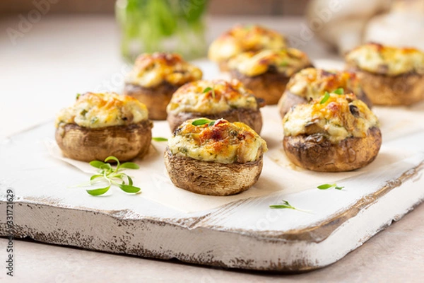 Obraz Stuffed mushrooms with cheese, delicious baked appetizer, traditional starter, golden crust.