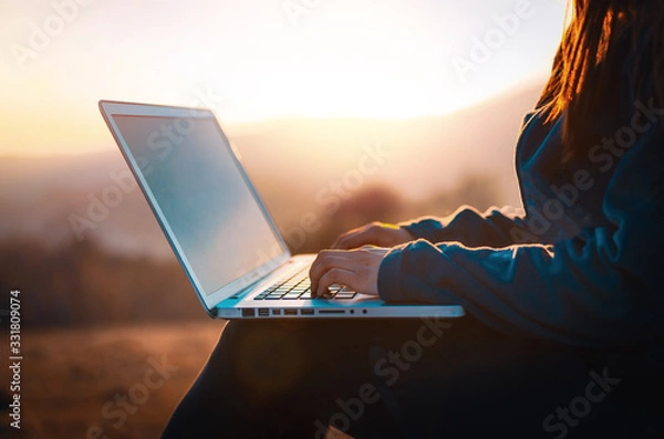 Fototapeta Using laptop computer in nature, technology and freedom concept