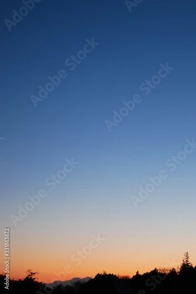 Fototapeta 森越しに見る美しい夕焼けの風景