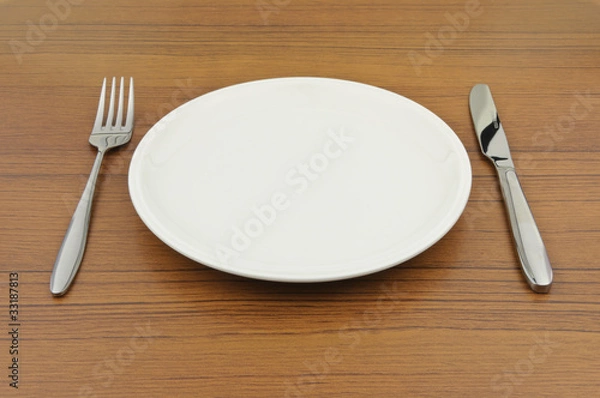 Obraz Empty dish, knife and fork on wood table