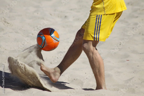 Obraz Mężczyzna grający w piłkę nożną na plaży