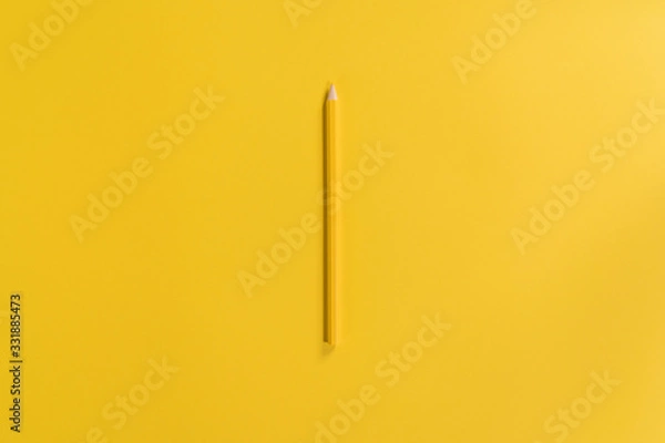 Fototapeta Yellow pencil on the yellow background. Top view of the pencil in the centre of the frame. Minimalism. Clean looking background. Template with copy space. One object