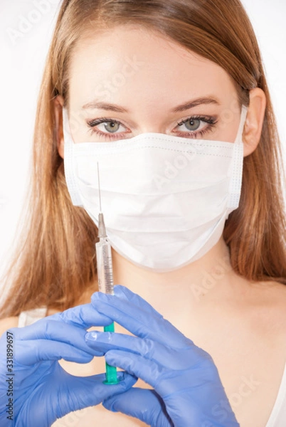 Obraz Nurse wearing mask holding syringe with vaccine against coronavirus covid-19 SARS-CoV-2