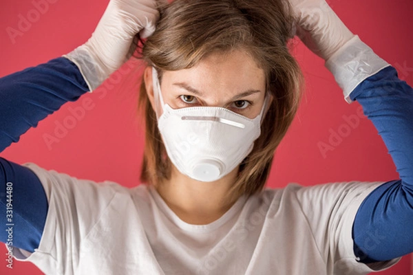 Obraz nurse surgical gloves puts on molded mask to prevent coronavirus infections and prevent the spread of the world pandemic