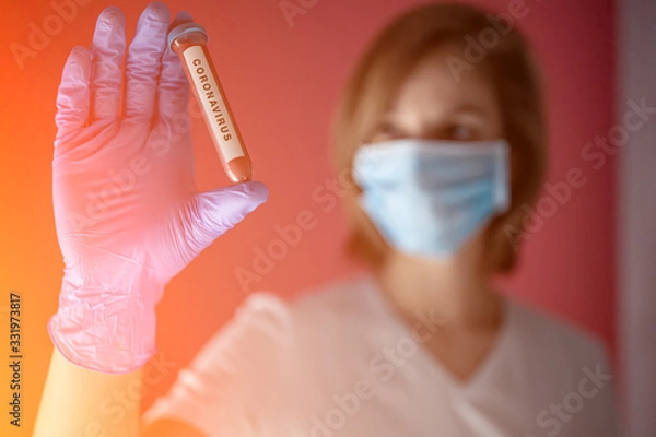 Fototapeta nurse wearing a mask, analyzes test tube of blood infected by coronavirus, generated in china, widespread in Italy and also arrived in the us with the risk of a 2019-ncov flu pandemic and deaths 