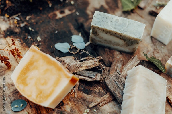 Fototapeta Various handmade natural soaps on a vintage wooden table with decoration