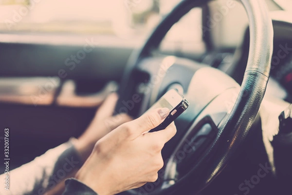 Fototapeta Woman using smartphone during traffic jam on road. vintage filter