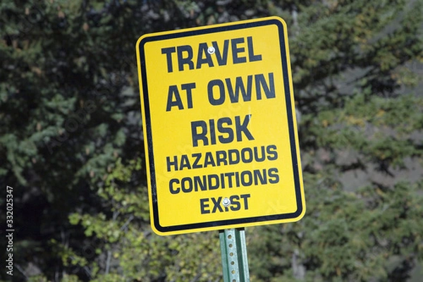 Obraz Yellow warning sign reading Travel At your own Risk alerting travelers that hazardous conditions exist