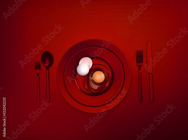 Fototapeta Red dishes with a broken egg and shell on a plate. Ceramic dishes with a fork, spoon and knife. For cafes, posters, breakfasts and dinners. Copyspace for your individual text