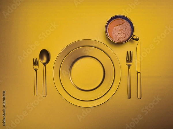 Fototapeta Cup of coffee with blue plates, fork, knife and spoon, top view. Ceramic dishes with a set of cutlery. Empty blue dishes for breakfast or dinner in a restaurant. Copyspace for your individual text.