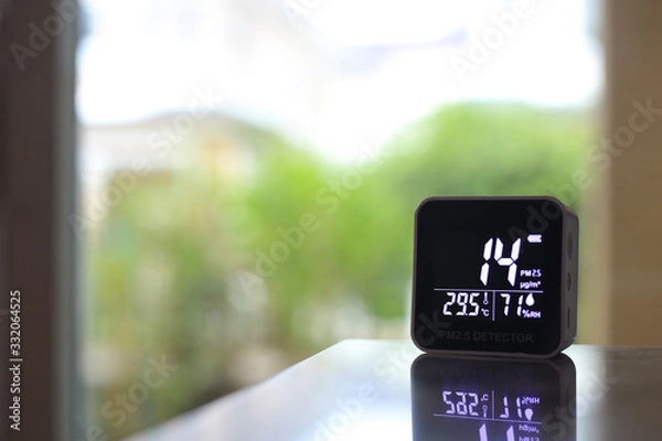 Obraz air quality sensor placing on a table indoor. sensor found small amount of air pollution of PM 2.5 the poisonous harmful particulate matter invisible dust from open field fire. man-made disasters.
