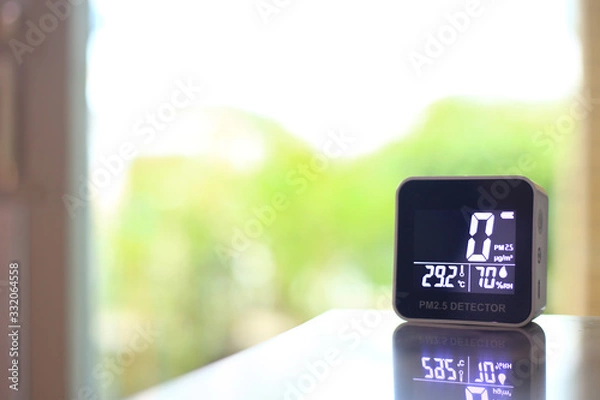 Obraz air quality sensor placing on a table indoor. sensor found small amount of air pollution of PM 2.5 the poisonous harmful particulate matter invisible dust from open field fire. man-made disasters.