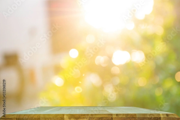 Fototapeta Product display on brown wooden table Against the bokeh background of trees and sunlight