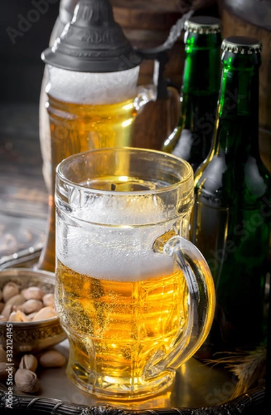 Fototapeta Light beer in a glass on a table in composition with accessories on an old background