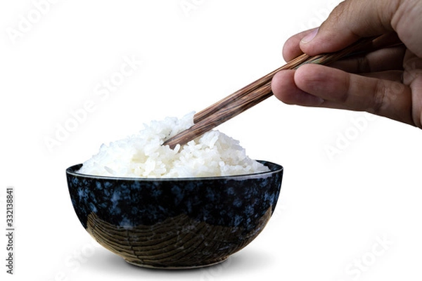 Fototapeta Cooked jasmine rice in ceramic cups and chopsticks holding hot jasmine rice with hand. isolated on white background. with clipping paths.