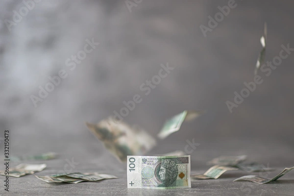 Fototapeta Polskie pieniądze na biurku, w tle spadające nominały 100 złotych, polska waluta