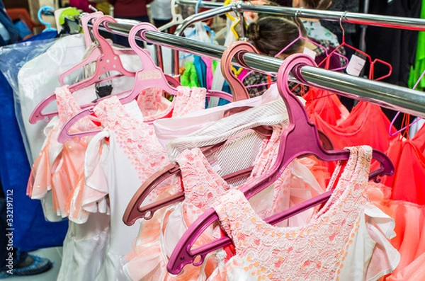 Obraz A row of stage costumes for upcoming performances by dance actors hangs on a floor hanger.