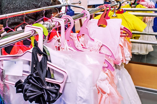 Obraz A row of stage costumes for upcoming performances by dance actors hangs on a floor hanger, toned.