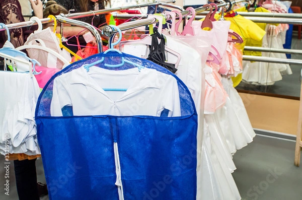 Obraz A row of stage costumes for upcoming performances by dance actors hangs on a floor hanger.