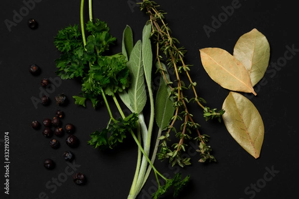 Fototapeta Sage, parsley, thyme, laurel, juniper, herbs on a black background. minimalistic, modern, with copy space