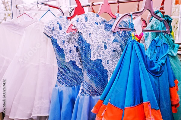 Obraz A row of stage costumes for upcoming performances by dance actors hangs on a floor hanger, toned.