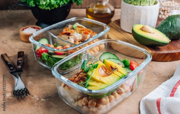 Fototapeta Healthy meal prep containers with chickpeas, chicken, tomatoes, cucumbers and avocados. Healthy lunch in glass containers on beige rustic background. Zero waste concept. Selective focus.
