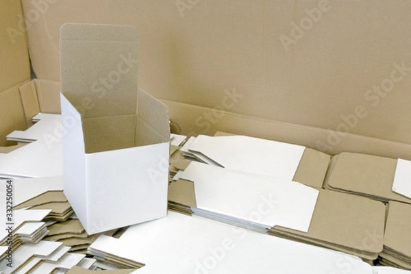 Obraz Folded cardboard box stands on disassembled. A lot of packaging for mugs. Disassembled condition, not folded. White color outside. Wholesale and retail trade. Production of souvenirs.