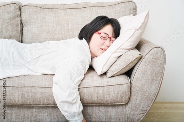 Fototapeta ソファーの上で寝る女性