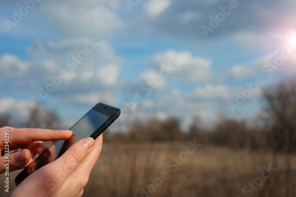 Obraz  phone in hands on nature background