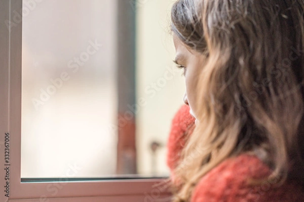 Fototapeta Enfant boudant devant une fenêtre