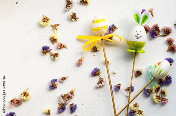 Obraz  Easter bunny and eggs on a white background with flowers