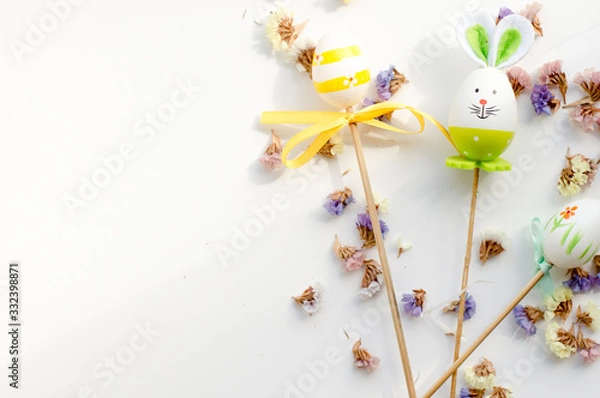 Obraz  Easter bunny and eggs on a white background with flowers