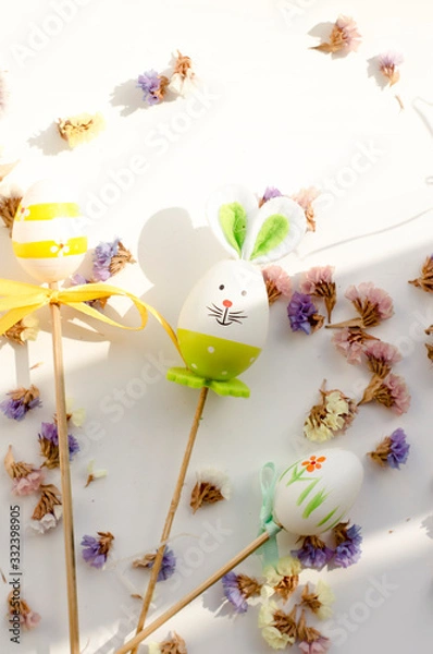 Obraz  Easter bunny and eggs on a white background with flowers