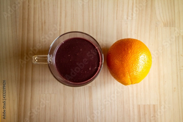 Obraz ガラスのマグカップのアサイードリンクとオレンジ１個 a glass cup of açaí drink and an orange 2