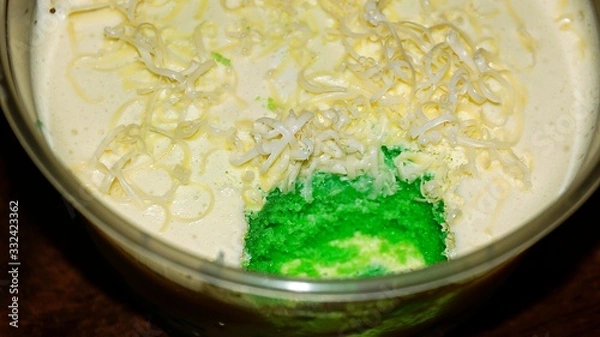 Obraz Close up Pandan leaf cheesecake on wooden background. Selective focus depth of field. (image contain certain grain or noise and soft focus when view at full resolution).