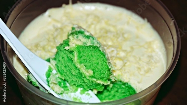 Obraz Close up Pandan leaf cheesecake on wooden background. Selective focus depth of field. (image contain certain grain or noise and soft focus when view at full resolution).