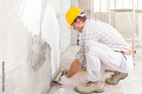 Fototapeta Builder applying new plaster to a wall indoors