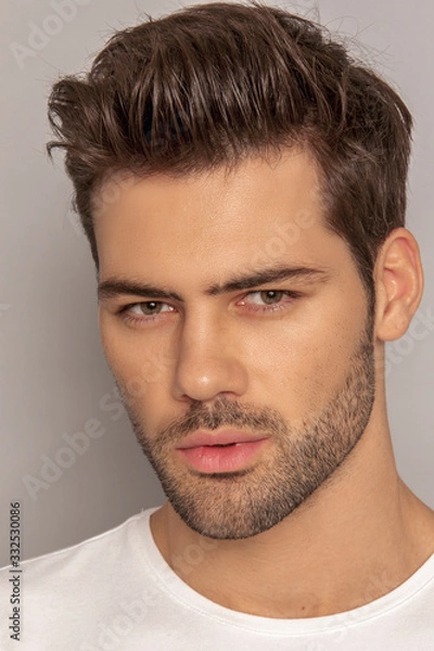 Fototapeta Muscle strong face beautiful stripped male model portrait in denim blue jeans white t-shirt on grey isolated font background with shadow