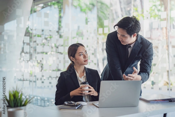 Fototapeta Group of young asian modern business people talking and smiling during the meeting in office.