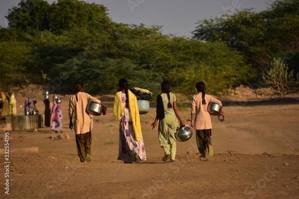 Obraz インドのラジャスタン州のジャイサルメール
クーリー村の共同井戸で水を汲むインド人女性
水瓶を運ぶ、村の若い女性達