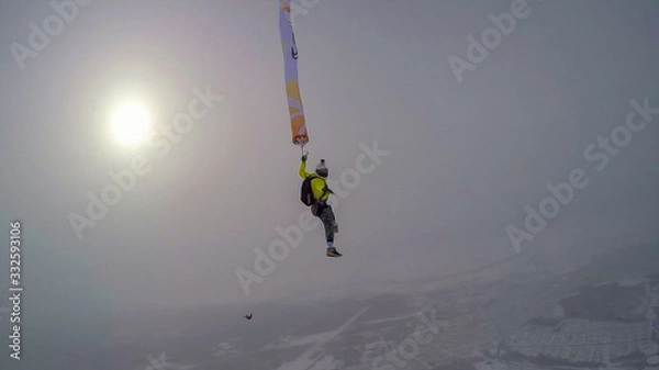 Fototapeta Investment. Parachutist performs an acrobatic trick in the air. Flying men make professional jump. Extreme as a hobby. 