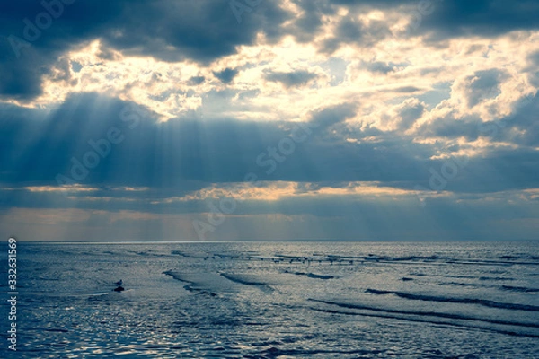 Fototapeta Rays of the sun through the clouds over the Baltic Sea