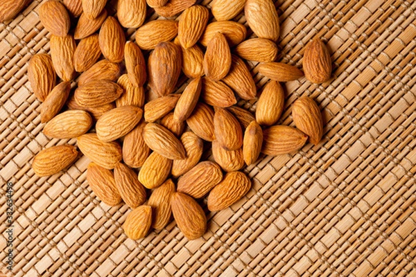 Fototapeta Almonds nuts shot large on a wooden background. Background for healthy eating and vegetarianism.