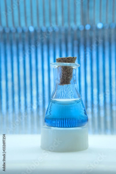 Obraz Test tube with color solution on blue laboratory background